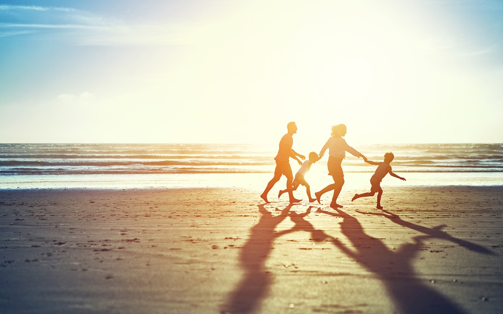 Family Running Along Beach